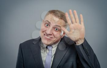 Closeup portrait of happy bashful socially awkward young man with big black glasses waving with hands, isolated on white background. Positive emotion facial expression feelings, situation, reaction