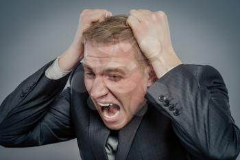portrait of businessman putting hands on head and shouting. Concept of shock,  headache and high temperature