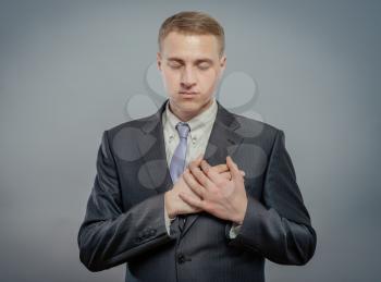 Businessman taking oath with fist over heart.