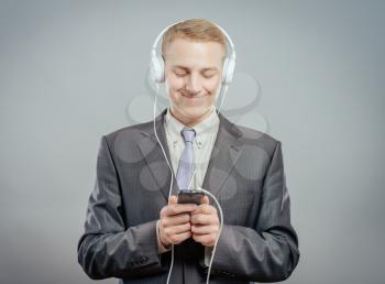 Man wearing suit listening music on phone 