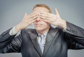 young businessman put his hands over eyes