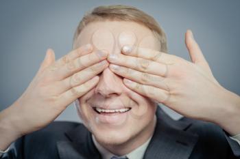 young businessman put his hands over eyes