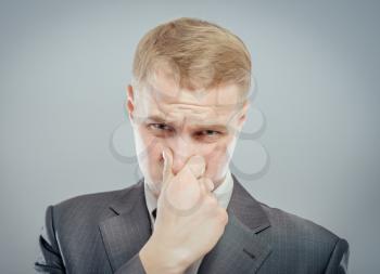 Young business man close up. Grabbing his nose with his fingers