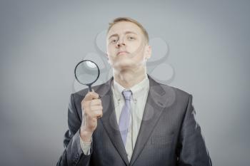 portrait of a young man holding a magnifying glass