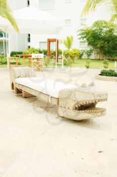 Home exterior patio with handcraft wooden sofa with an aligator appearance. 