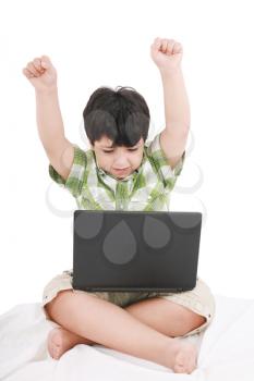 cute little boy with laptop in his bed on white 