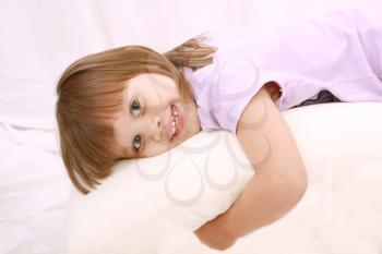 Beautiful little girl lying on bed 