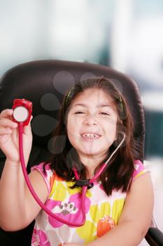 Cute little girl is playing doctor with stethoscope, isolated over white 
