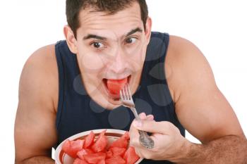 Young man eating a fresh water melon. 
