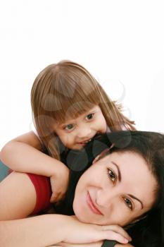 A portrait of a mother and her baby girl lying on the floor and smiling over white background 

