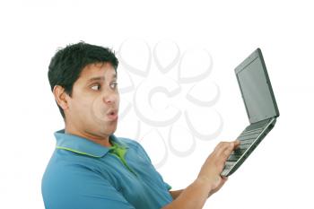 Young man standing, holding a laptop computer, working, looking down, isolated on white. 