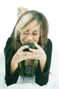 Teenage girl chatting with cell phone lying down  - isolate 