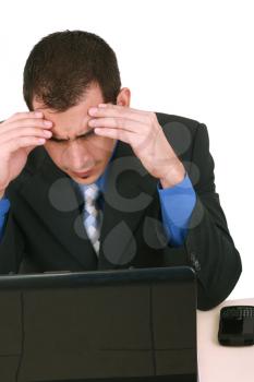 Image of businessman touching his head while looking at monitor with tired expression 
