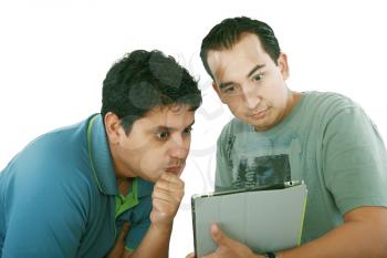 Two friends looking surprised at tablet computer against a white background 