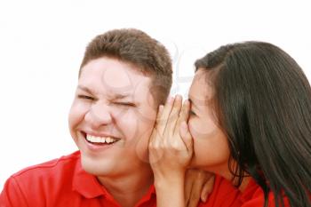 woman telling a man a secret - surprise and fun faces - over a white background