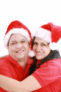 Young happy couple near with Santa hats. Isolated over white background 
