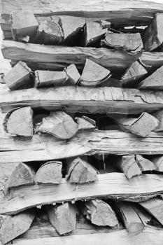 Background of dry chopped firewood logs stacked up on top of each other in a pile 
