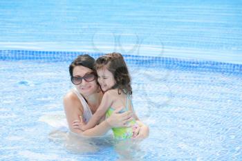 Mother and her baby having fun in the swimming pool. 