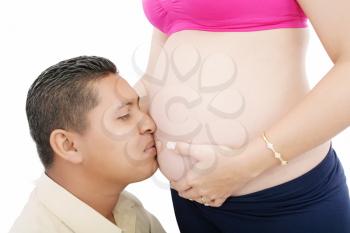 Close up of a man kissing the belly of his lovely pregnant wife