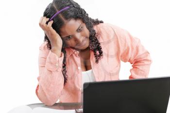 Young black female professional with hand in hair over laptop