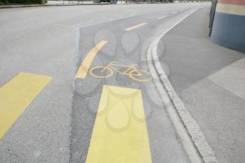 Yellow painted sign for bikes on asphalt 