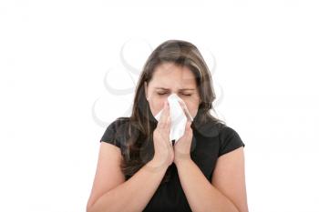 A woman with a cold or allergy wiping or blowing her nose. 