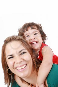 Portrait of happy daughter enjoying a piggyback ride on mothers back, isolated over white. Focus on the child
