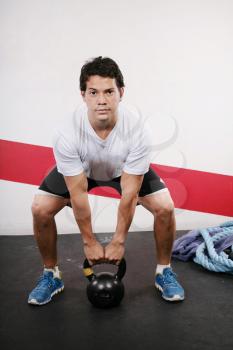 Young man Lifting Crossfit Kettle Bell