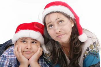 Mother and son in Santa hats smiling and looking up