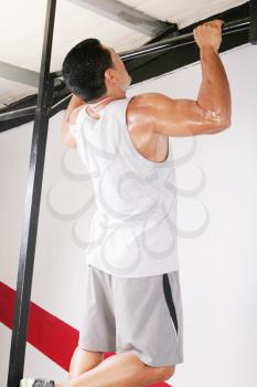 strong man performing pull ups in a bar 