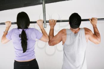 Young adult fitness woman and man preparing to do pull ups in pull up bar