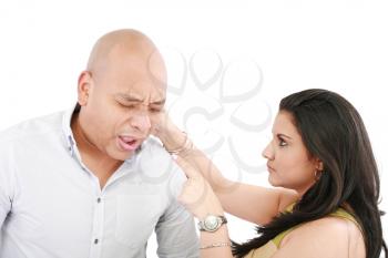 Beautiful Caucasian woman twisting boyfriend's ear while he screams 