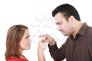 Young couple pointing at each other against a white background 
