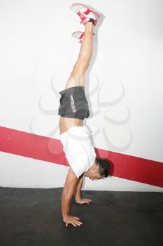A man does a gymnastic handstand in the gym 