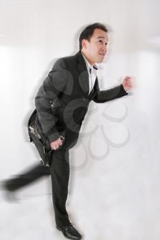 Full length of business man with briefcase running on white background