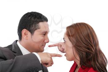 Young couple pointing at each other against a white background 