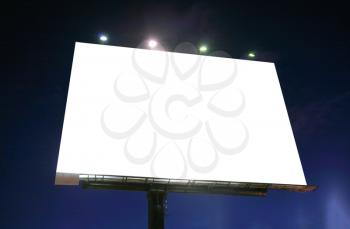 Blank illuminated billboard over evening sky 