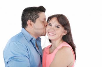 Close-up portrait of woman being affectionately kissed by her husband