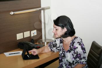 Business woman sitting in her office using a tablet computer 