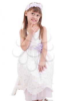 little girl wearing white dress and posing on chair on white background 