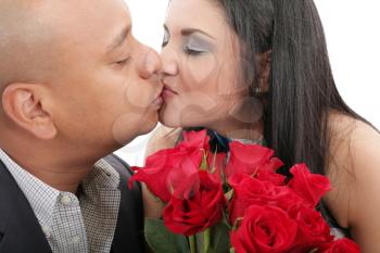 Close up of couple kissing holding a bouquet of red roses
