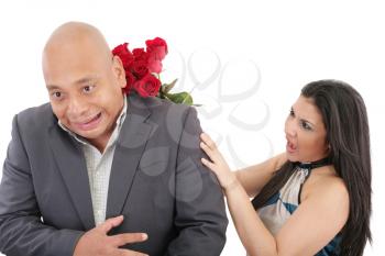 Woman striking his boysfriend with a bouquet of red roses.  Focus on the woman.