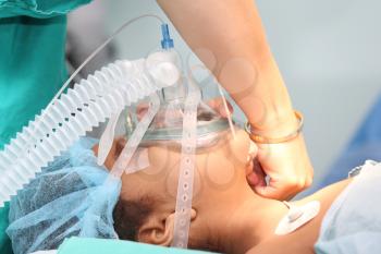 Nurse preparing the oxygen mask to an undentified patient for the surgery