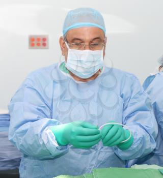Doctor preparing a catheter for insertion on a patient. Slide Safe-T-J wire guide straightener.