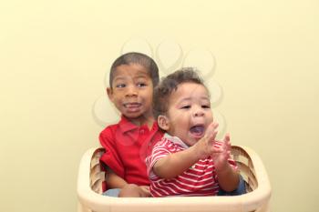 Two brothers of mixed race.  Focus in the front baby.