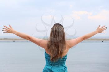 woman standing back with open arms