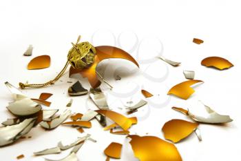 Pieces of broken golden ball on white, christmas background