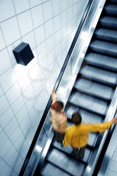 Couple moving on escalator, with motion blur