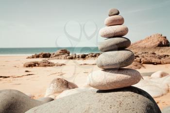 Balanced stones in retro style on the beach