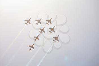 Arrow formed by French Air force, eight backlighted alpha jets of Patrouille de France at airshow